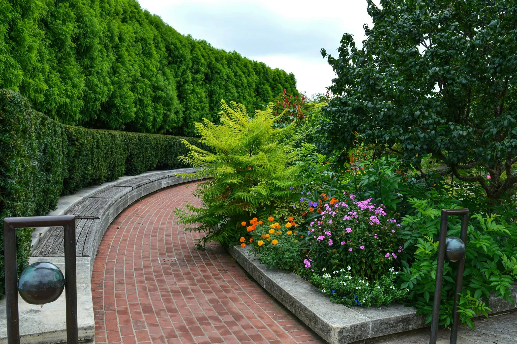 Curving brick path lined with planted beds