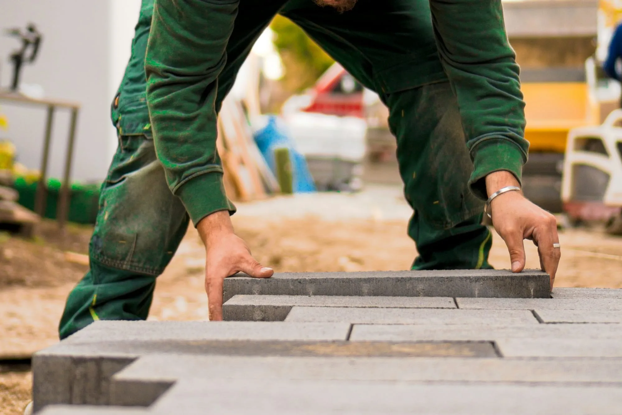 Landscaper setting a concrete paver into place